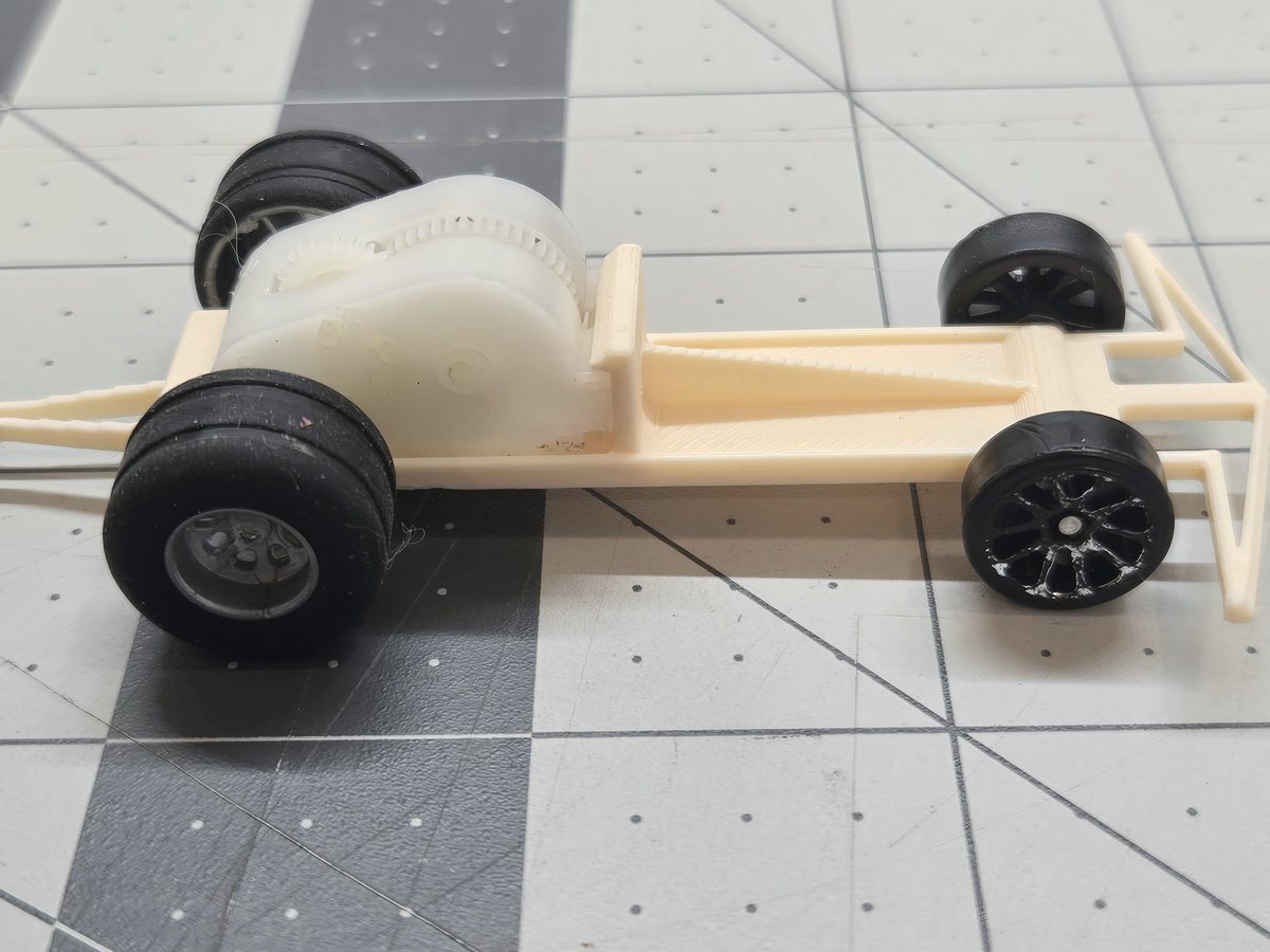 A 3D-printed dragster chassis with a Wallop pull-back spring motor mounted between its rear wheels