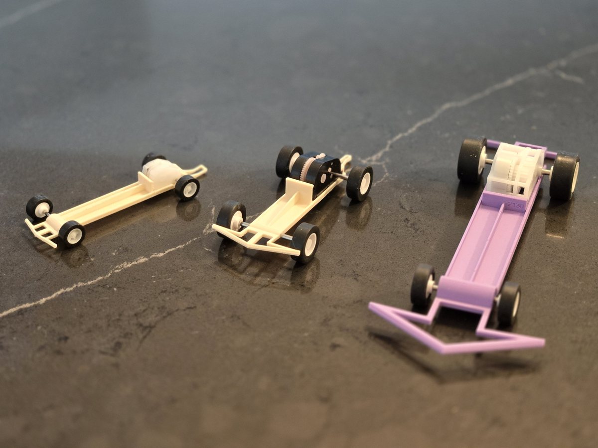 Three 3D-printed dragster chassis of increasing size, each built around one of the three Wallop wind-up gearbox motors