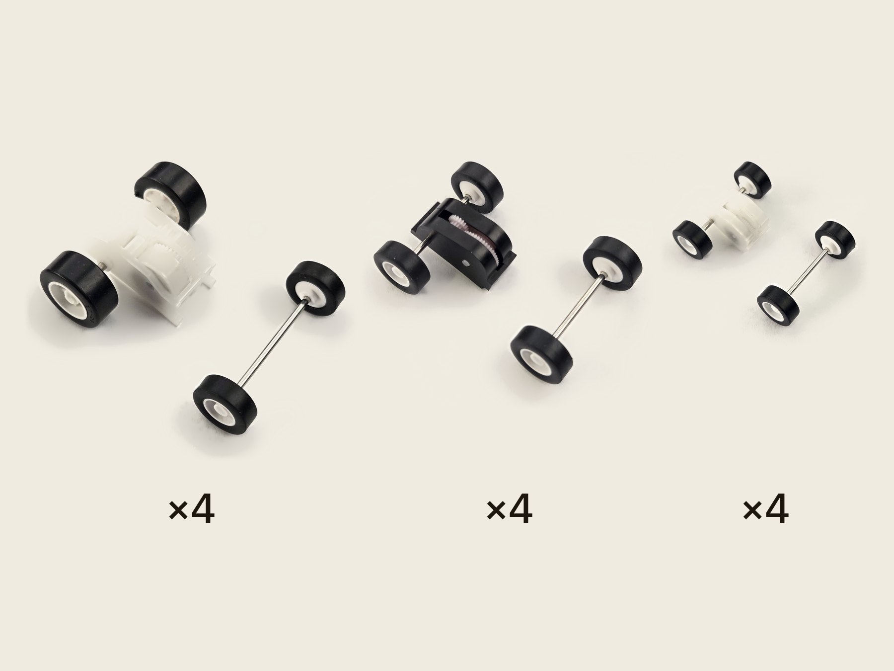 Twelve pull-back motors, four of each size in rows from largest to smallest, with their matching front wheel-and-axle sets